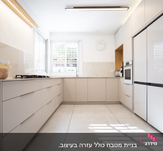 מטבח מודרני עם ארונות לבנים ותנור אפייה